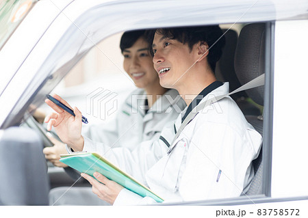 作業着を着てトラックに乗る若い男女 作業着を着てトラックに乗る若い男女 83758572