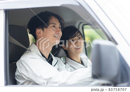 作業着を着てトラックを運転する若い男女 作業着を着てトラックを運転する若い男女 83758707