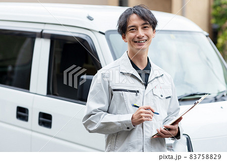 住宅に訪問する作業着を着た男性 83758829