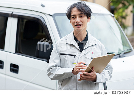 住宅に訪問する作業着を着た男性 83758937