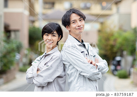 住宅に訪問する作業着を着た男女 83759187