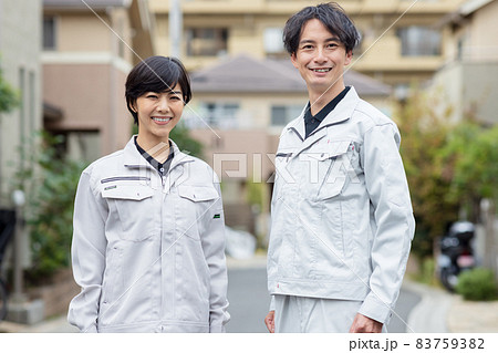 住宅街に立つ作業着を着た男女 住宅街に立つ作業着を着た男女 83759382