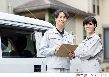 住宅に訪問する作業着を着た男女 住宅に訪問する作業着を着た男女 83759463