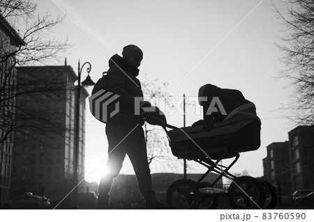 Happy young mother with pram during the walk Happy young mother with pram during the walk 83760590