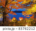 ライトアップされた紅葉の間からのぞく山と湖 83762212
