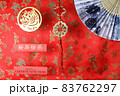 Golden chinese tiger symbol, chinese bamboo paper fan and fortune hunger from lucky coins on red fabric with birds and dragons. Chinese New Year of the Tiger 2022. Translation: happy new year 83762297