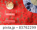 Golden tiger symbol and chinese bamboo paper fan on red fabric with traditional chinese ornament birds and dragons. Chinese New Year of the Tiger 2022. Translation: happy new year 83762299