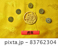 Gold tiger symbol, five lucky coins with chinese zodiac on yellow fabric with traditional chinese ornament with clouds. Chinese New Year of the Tiger 2022. Translation: year of the tiger 83762304