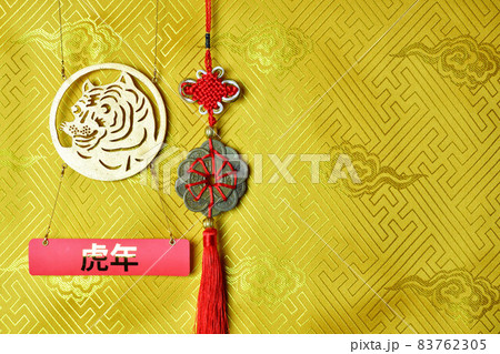 Gold tiger symbol, fortune hunger from lucky coins on yellow fabric with traditional chinese ornament with clouds. Copyspace. Chinese New Year of the Tiger 2022. Translation: year of the tiger Gold tiger symbol, fortune hunger from lucky coins on yellow fabric with traditional chinese ornament with clouds. Copyspace. Chinese New Year of the Tiger 2022. Translation: year of the tiger 83762305