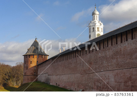 View of the wall of the Novgorod Kremlin - Detinets with the Metropolit Tower on an autumn day. 83763361