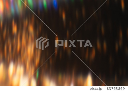 Lens flare overlay. Blur sparks. Disco illumination. Defocused golden orange colorful light flecks glow on dark night abstract background. 83763869