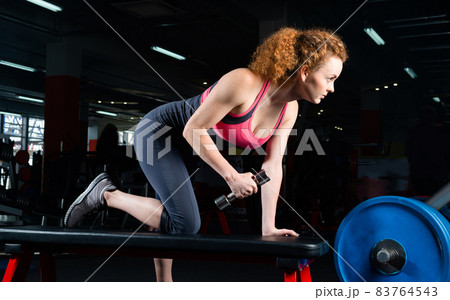 attractive young woman engaged with dumbbells in the gym. 83764543