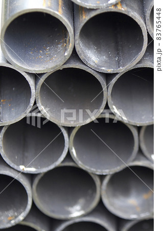 Metal profile pipe of round section in packs at the warehouse of metal products Metal profile pipe of round section in packs at the warehouse of metal products 83765448