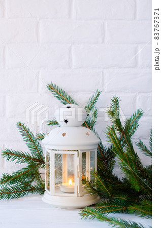 Scandinavian home decor. White lantern and fir branches. 83767371