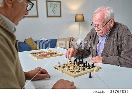 Senior people playing chess together Senior people playing chess together 83767852
