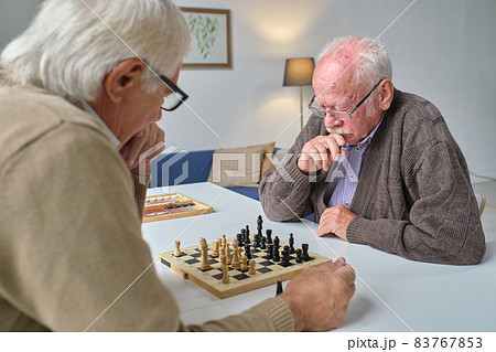 Friends playing chess at home 83767853