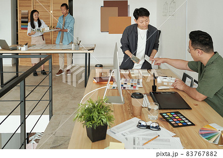 Young female designer or architect consulting with colleague Young female designer or architect consulting with colleague 83767882