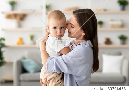 Mother's Care Concept. Beautiful Young Woman Holding Adorable Toddler Child In Hands, 83768628
