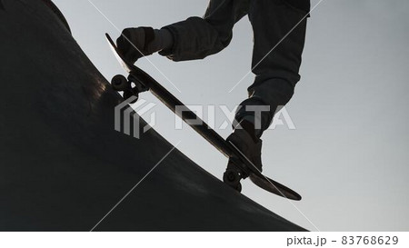 teenager having fun with skateboard park silhouette. High quality beautiful photo concept 83768629