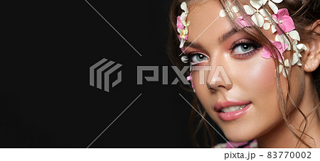 Beautiful caucasian woman with flowers on black background. 83770002