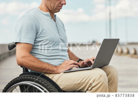 Man in Wheelchair using Laptop Man in Wheelchair using Laptop 83773838