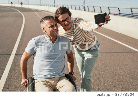 Couple with Man in Wheelchair Taking Selfie Photo Couple with Man in Wheelchair Taking Selfie Photo 83773904