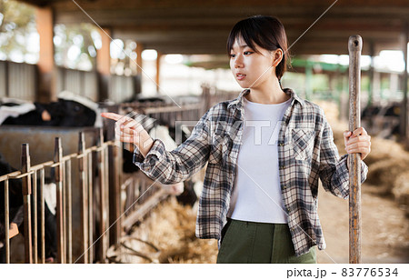 Portrait of smiling young chinese woman engaged in dairy farm Portrait of smiling young chinese woman engaged in dairy farm 83776534