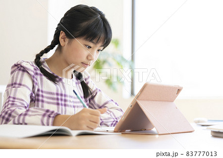 タブレットを使って勉強する小学校高学年の女の子 83777013