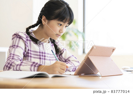 タブレットを使って勉強する小学校高学年の女の子 83777014