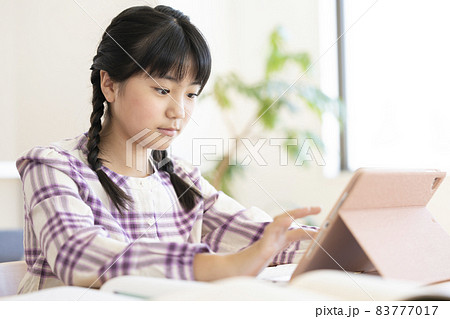 タブレットを使って勉強する小学生の女の子 83777017