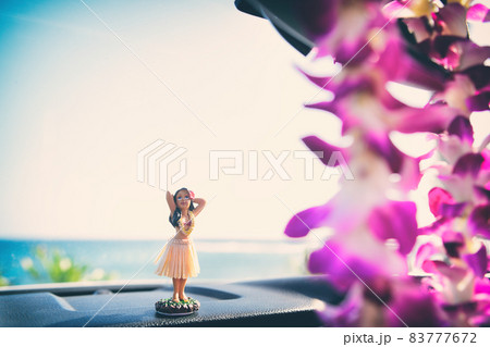 Hawaii road trip - car hula dancer doll dancing on the dashboard in front of the ocean. Tourism and travel freedom concept. Hawaii road trip - car hula dancer doll dancing on the dashboard in front of the ocean. Tourism and travel freedom concept. 83777672