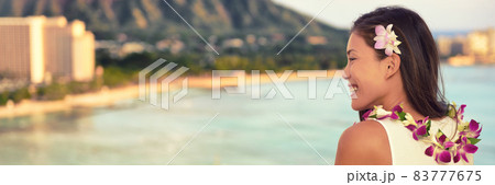 Hawaii Asian woman wearing lei necklace, hair flower for hula dancing luau party. Aloha girl at luxury resort sunset view of beach landscape, panorama banner. Hawaiian vacation summer travel. 83777675