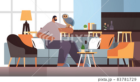 man with owl guy taking care of pet animal bird living room interior horizontal 83781729