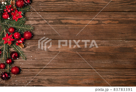 Festive Christmas background red balls green branches spruce serpentine sequins wooden dark background. Festive Christmas background red balls green branches spruce serpentine sequins wooden dark background. 83783391
