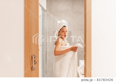 Surprised woman caught unawares in bathroom after taking a shower Surprised woman caught unawares in bathroom after taking a shower 83783426