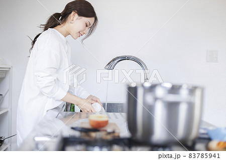 キッチンで皿洗いをする女性 83785941