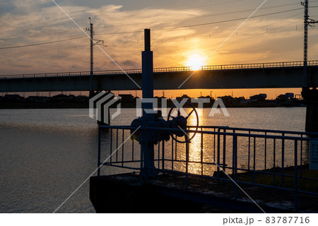 夕陽に照らされた水門ハンドルのシルエット 83787716