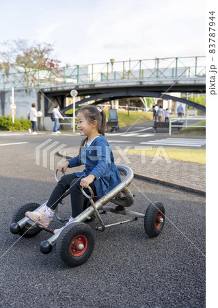 金川の森でサイクルカートに乗る女の子 83787944