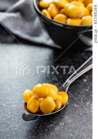 Pickled yellow Lupin Beans in spoon. 83788268