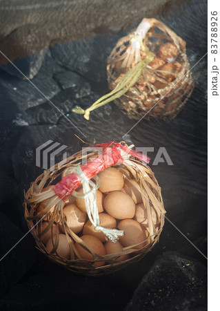 Big baskets of many eggs boiled under clear hot mineral water pond of hot spring. Big baskets of many eggs boiled under clear hot mineral water pond of hot spring. 83788926