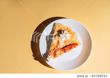 Slice of pizza with seafood on white plate Slice of pizza with seafood on white plate 83789034