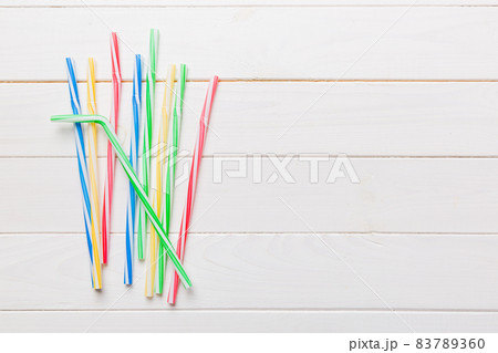 Drinking straws for party on Colored background. Top view of colorful plastic disposable straws for summer cocktails. different straws for juice with copy space Drinking straws for party on Colored background. Top view of colorful plastic disposable straws for summer cocktails. different straws for juice with copy space 83789360