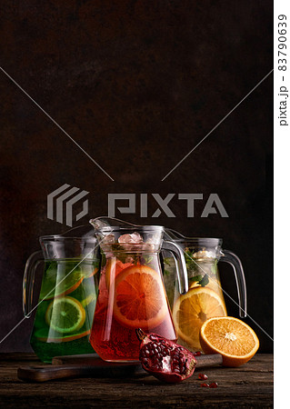 Set of colorful lemonades in jugs. On dark background 83790639