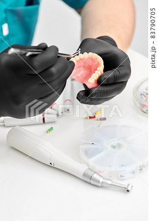 Orthodontist is working on cast of jaw. Orthodontics. Orthodontist makes a denture. 83790705
