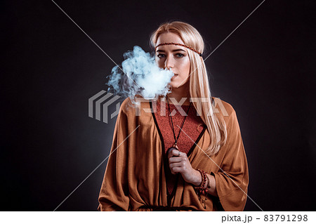 Young woman in the Boho style blowing smoke 83791298