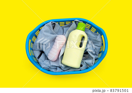 Jeans in laundry basket on yellow background. Jeans in laundry basket on yellow background. 83791501