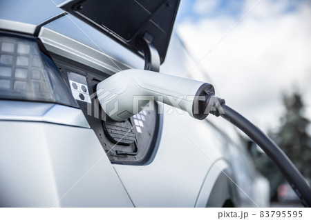 Charging connector connected to the electrical socket of a hybrid car. Charging connector connected to the electrical socket of a hybrid car. 83795595