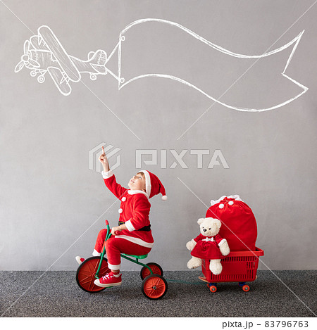 Happy child riding bike. Christmas holiday concept 83796763
