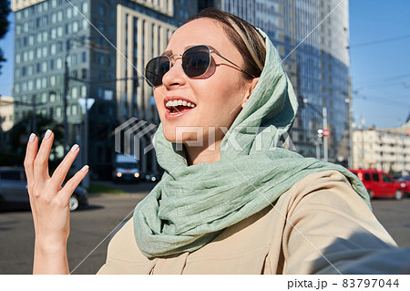 Muslim girl smiling and chatting with someone while holding video call during traveling 83797044