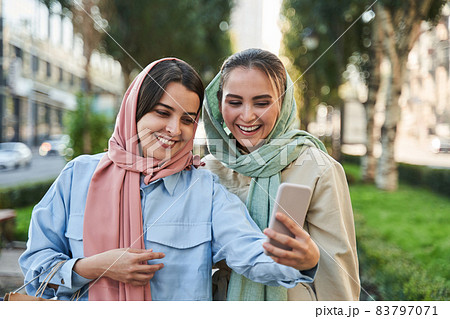 Islamic female friends making selfie on smartphone while staying at the city 83797071
